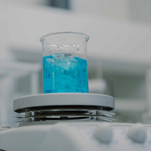 A beaker with blue liquid on a scale.